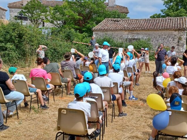 Des participants de dos, assis sur des chaises alignées comme dans une classe